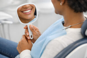 Dental patient admiring their smile in a handheld mirror