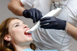 Dentist scanning patient teeth with 3D CBCT scanner for implant planning
